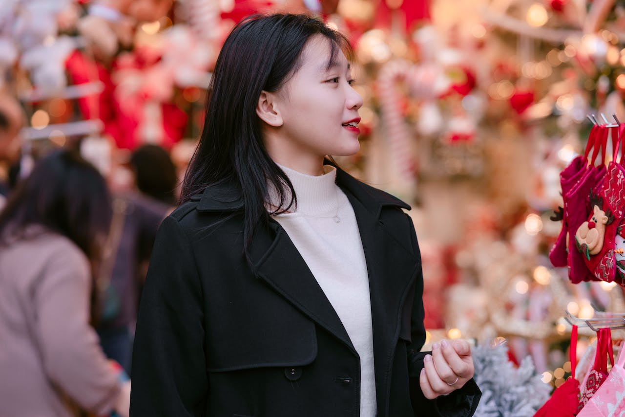 Young Woman in a Black Coat Over a White Sweater Doing Christmas Shopping